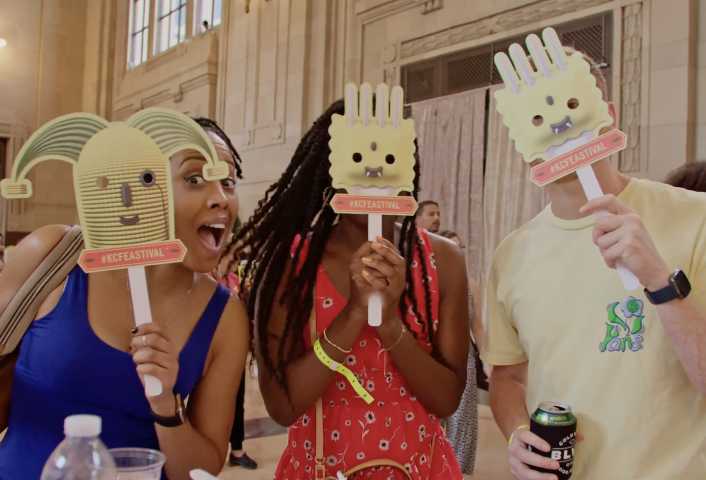 Three people at Feastival event holding up different hunger monster-head masks