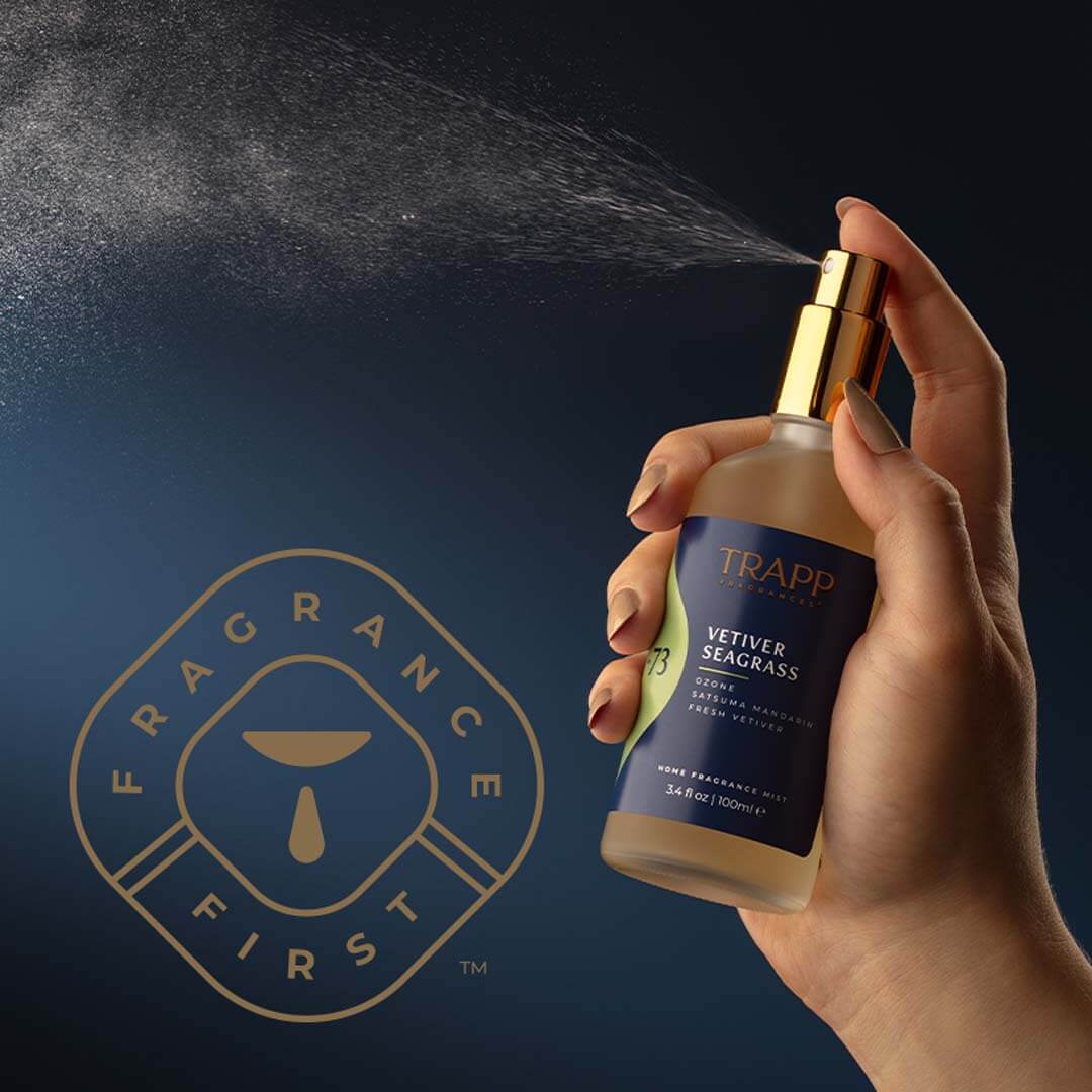 Hand holding and spraying Trapp Fragrances Spray with "Fragrance First" icon.