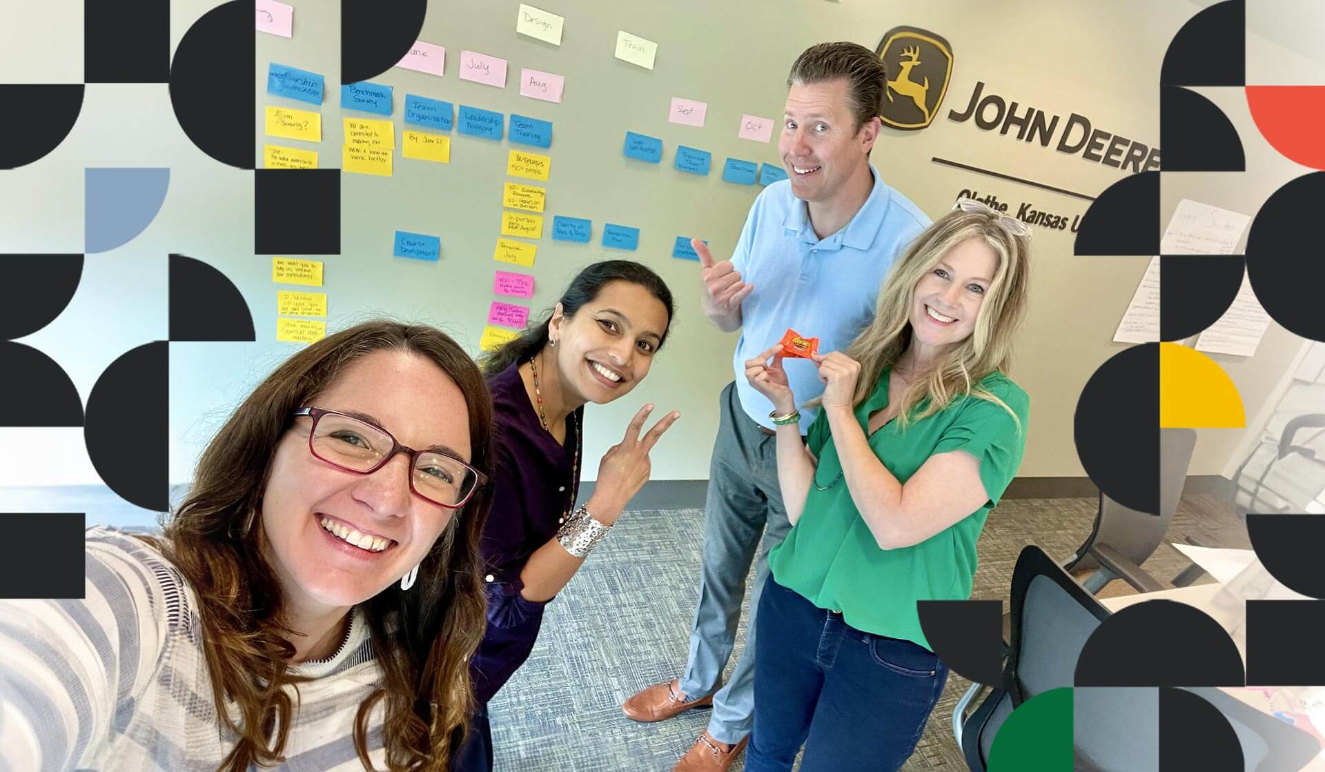 Amanda Hembree with people from a John Deere training session standing in front of a wall of post-it notes – all smiling and looking at the camera