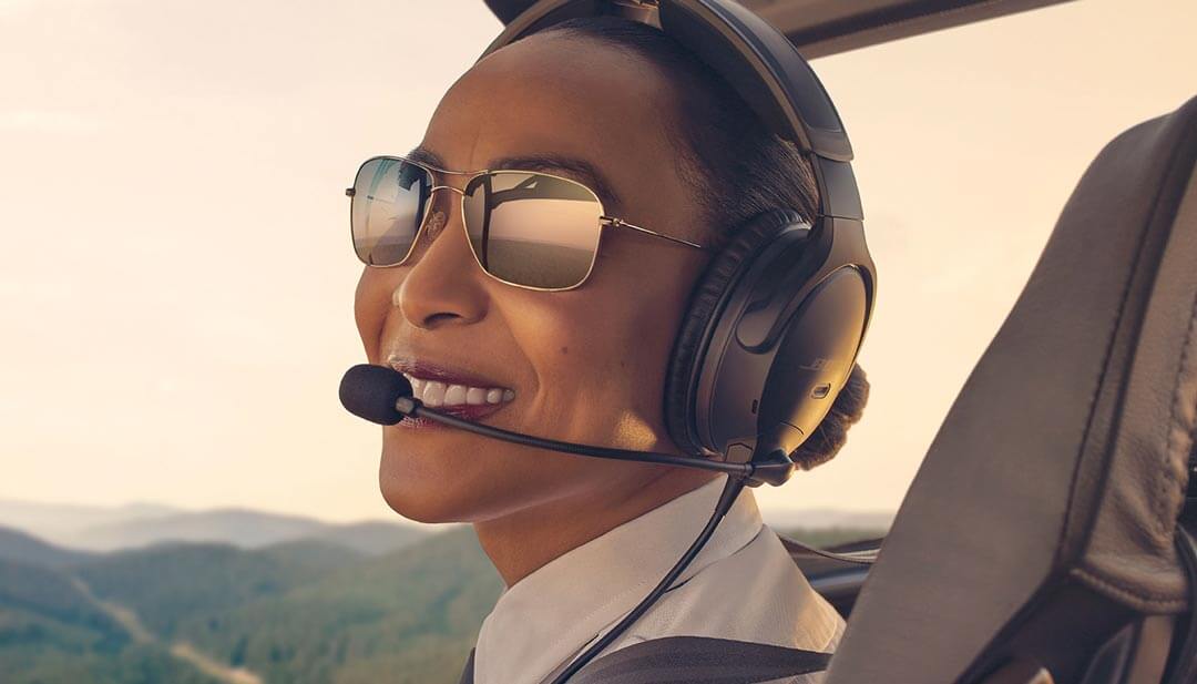 Woman pilot wearing sunglasses and Bose Aviation A30 headset during a flight.