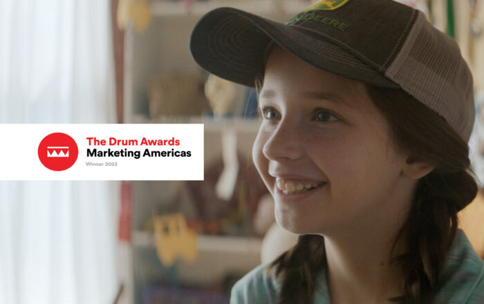 Logo for The Drum Awards Marketing Americas Winner 2023 with image of young girl from John Deere's A Different Kind of Crown.