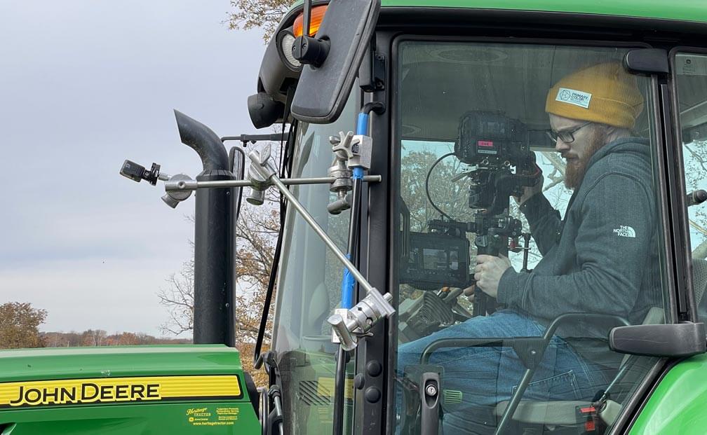 Signal Theory cinematographer shooting from inside a John Deere Tractor