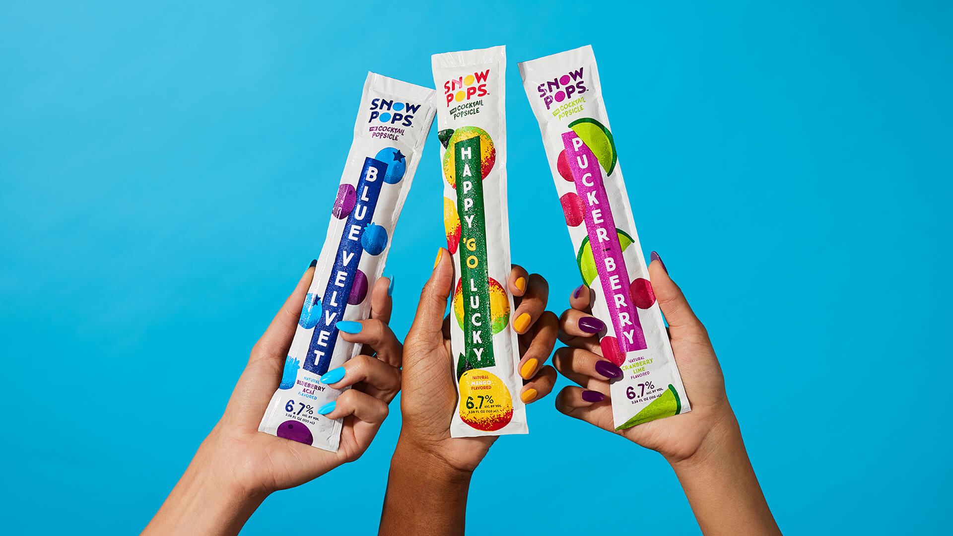 Close up of hands holding up 3 flavors of individual Snow Pops frozen cocktails in their long packaging.