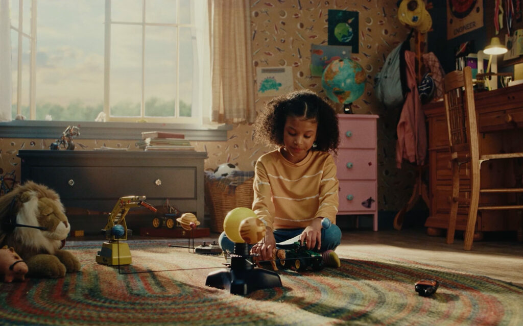 Still from John Deere's All Kinds of Fields spot of young girl playing with toy tractor in her bedroom